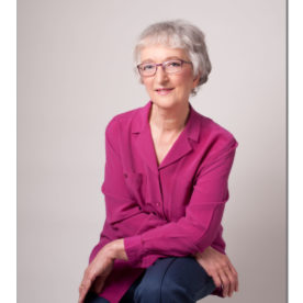 beautiful woman in a pink shirt posing on a stool after a a make-over session
