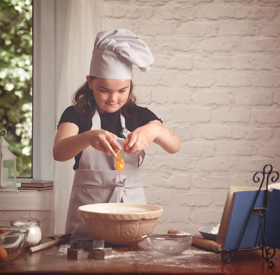 girl cracking an egg into a bowl